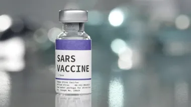 Tıbbi laboratuarda yanında şırınga bulunan SARS aşı şişesi..