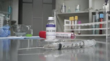 Aşı ve antikor şişesi tıp laboratuarında. Şırınga makro görüş için yavaşlıyor..