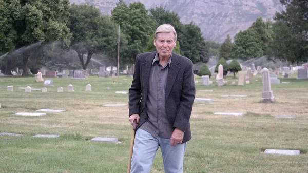 Älterer Mann Geht Über Friedhof Während Auf Bank Sitzt Familie — Stockfoto