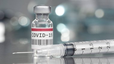 Coronavirus Covid-19 aşı şişesi tıp laboratuarında şırıngayla