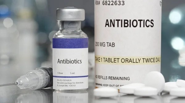 Şişede antibiyotikler ve şırıngayla laboratuarda haplar.