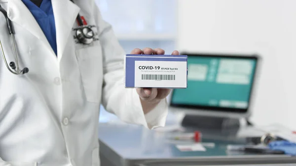 Doctor holding Covid-19 test kit in medical lab.