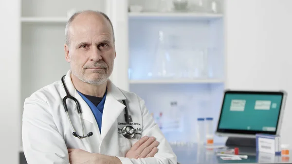 Doktor kollarını sıhhiye odasında sert bir şekilde kavuşturuyor..