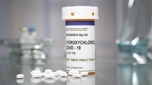Tıp laboratuarında hidroklorokin covid-19 hapı ve şişe.