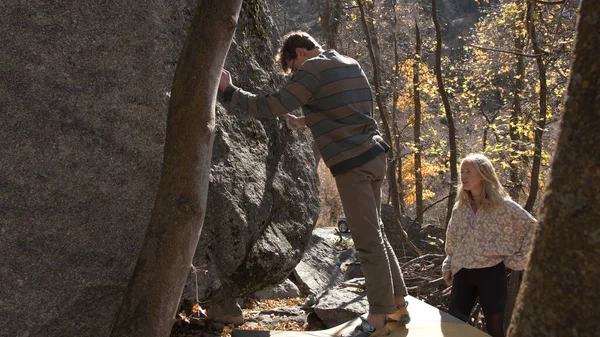Erkek ve kadın kayaya tırmanmaya hazırlanırken güvende olduklarından emin olmak için..