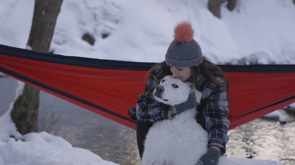 Hamakta oturan ve köpeğini köpek gibi okşayan bir kadın kışın kaçmak istiyor..