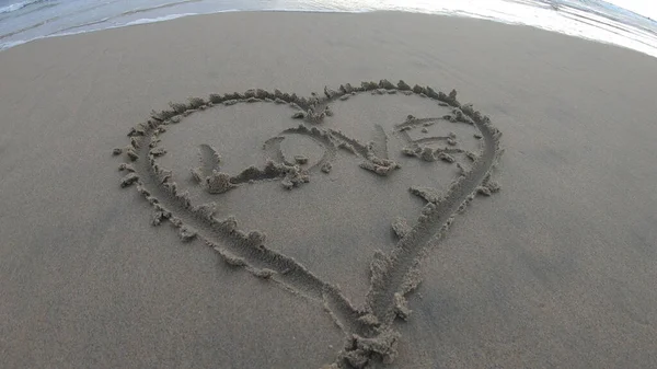 Kumsalda bir kalple kumlara yazılmış bir aşk..
