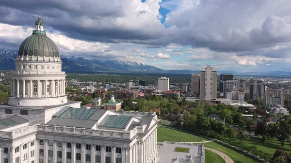 Salt Lake City Utah 'a doğru Capitol Binası üzerinden uçan hava manzaralı Wasatch Dağları manzaralı..