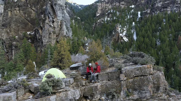 Pareja Vertiendo Bebidas Copas Campamento Mientras Sientan Borde Acantilado American Fotos de stock libres de derechos