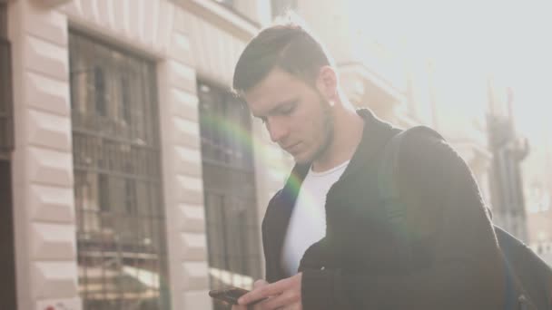 Man with smartphone walking by the city street — Stock Video