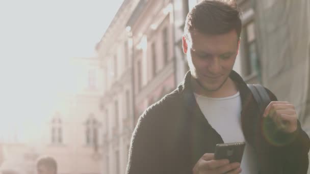 Man met smartphone wandelen door de stad straat — Stockvideo