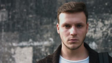 Kameraya bakarak ciddi bakışları ile çekici genç adam: 4 k görüntüleri