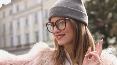 Gülümseyen kadın kentsel sokakta kendi fotoğraf çekme. Güzel beyaz esmer kız ile beyaz ceketli selfie yapar. Bir turist.