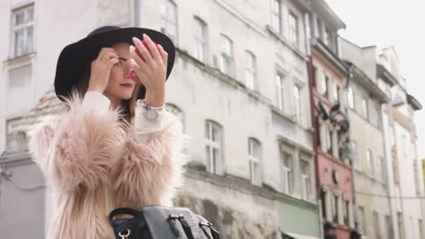 Mädchen sitzt im Outdoor-Café und verbessert ihr Make-up — Stockvideo