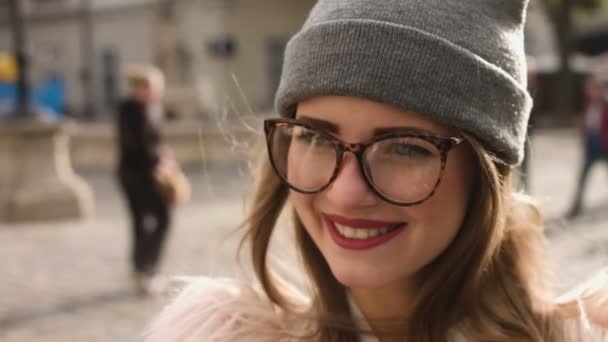 Leende kvinna du själv fotograferar i urban street. Vacker Brunett kaukasiska flicka i vit jacka med gör selfie. En turist. — Stockvideo