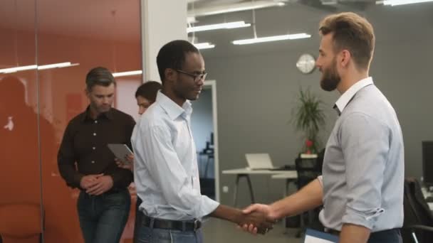 Jonge collega's handshaking na succesvol samenwerken. — Stockvideo