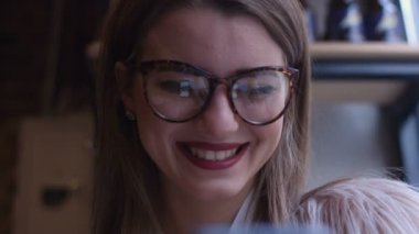 Kafede kahve içme telefon üzerinde app gülümseyen kullanan akıllı kız. Güzel çok kültürlü genç casual kadın profesyonel üstünde hareket eden telefon.