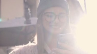 Kafede kahve içme telefon üzerinde app gülümseyen kullanan akıllı kız. Güzel çok kültürlü genç casual kadın profesyonel üstünde hareket eden telefon.