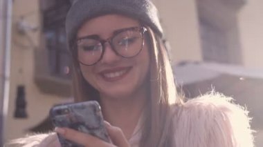 Kafede kahve içme telefon üzerinde app gülümseyen kullanan akıllı kız. Güzel çok kültürlü genç casual kadın profesyonel üstünde hareket eden telefon.