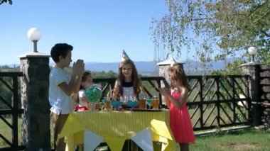 Beş küçük çocuklar pasta doğum günü partisinde ile sarı masaya oturabiliriz. Duvar üzerinde yazıt mutlu yıllar