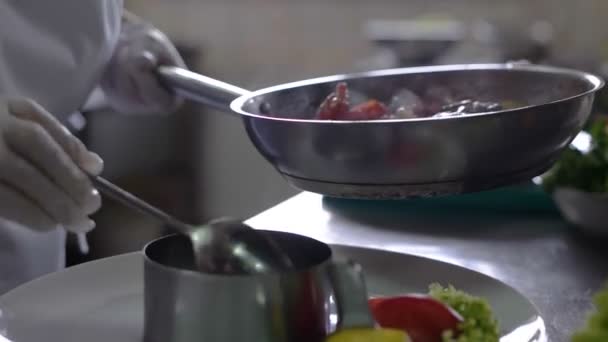 Zbliżenie, szefa kuchni kończąc przygotować danie rybne z deszczyk oliwy na jego plan pracy zawodowej i pokazano naczynie do aparatu — Wideo stockowe