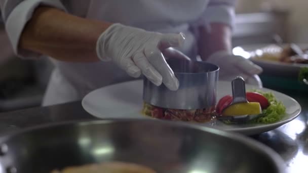 Primer plano de un chef terminando preparar un plato de pescado con una llovizna de aceite en su plan de trabajo profesional y mostrar el plato a la cámara — Vídeo de stock