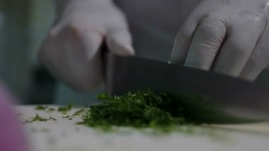 Genç kadın mutfak masasında yemek hazırlanıyor. İnsan sağlığı için iyi iş. Doğru beslenme ve sağlık. Hazırlamak ve yeşillikler için vegan doğrayın. Evde yemek. Gıda sanayi. Yavaş hareket kapatmak