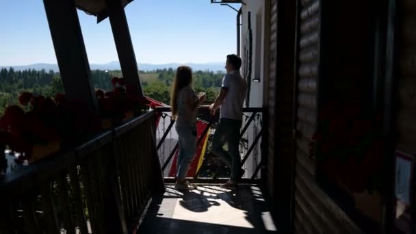 Счастливая пара пьет кофе на красивом балконе — стоковое видео