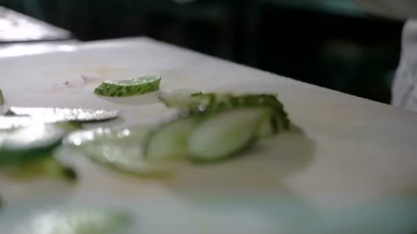 Cortando pepino e alface. Closeup de legumes cortados em tábua de corte de madeira. Stop motion animation, 4K . — Vídeo de Stock