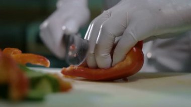 Kesme tahtası üzerinde bir havuç kırmızı biber ile doğrama Şef Close-Up.