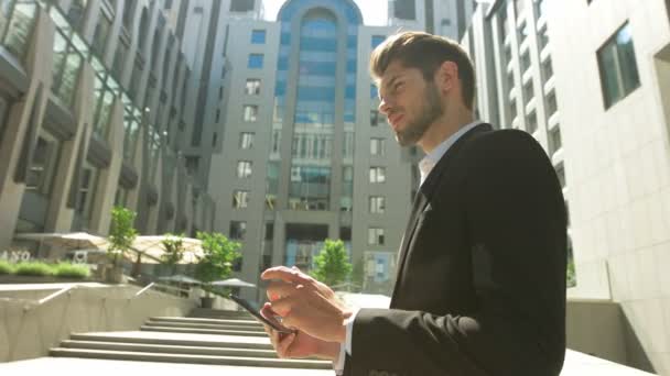 Joven usando su tableta frente a un centro de negocios . — Vídeos de Stock