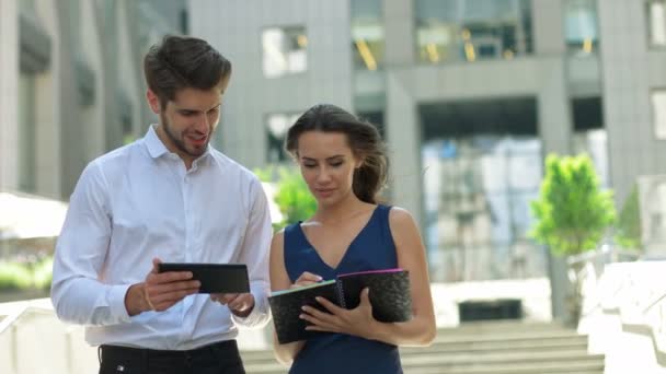 Two young business partners working on the street.Business partners discussing documents and ideas, standing in front of his office. — Αρχείο Βίντεο