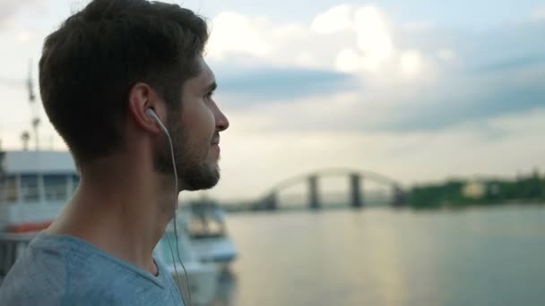 Чоловік слухає музику в центрі міста . — стокове відео