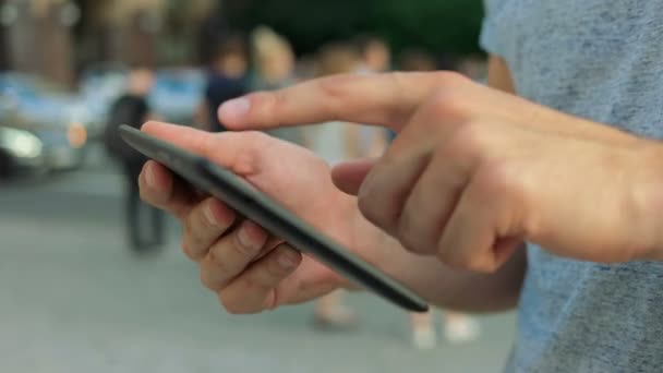 Gros plan des mains en utilisant une tablette dans la rue . — Video