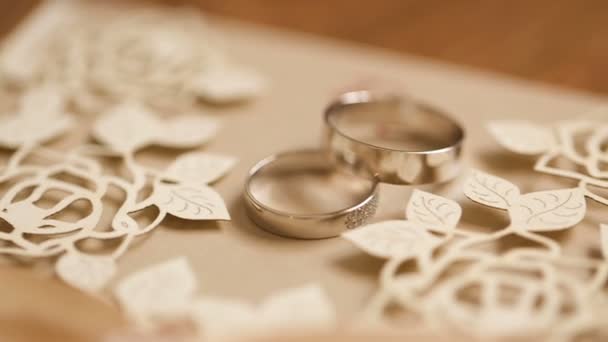 Anillos de boda girando con fondo texturizado — Vídeo de stock