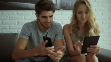Genç adam kız tablet kullanma sırasında yaptığı telefon Haberler gösterilen.