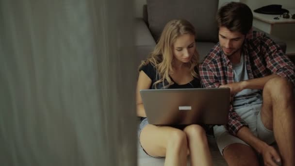 Νέοι που χρησιμοποιούν φορητό υπολογιστή στο σπίτι. — Αρχείο Βίντεο