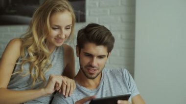 Şaşırtıcı kız ve onu adam evde tablet kullanma.