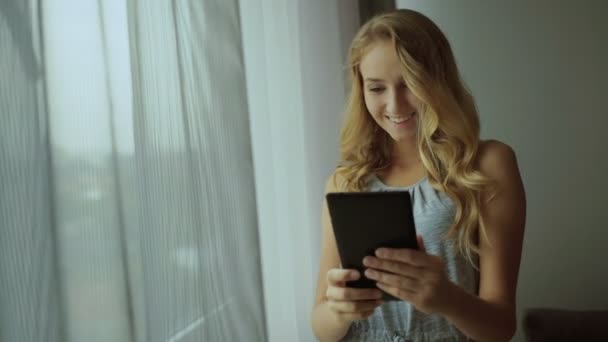Крупный план портрета счастливой молодой женщины, смотрящей на планшет с сенсорным экраном — стоковое видео