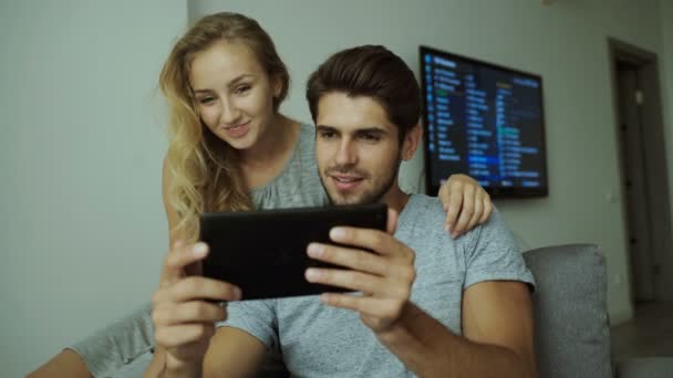 Двоє молодих людей використовують планшет вдома — стокове відео