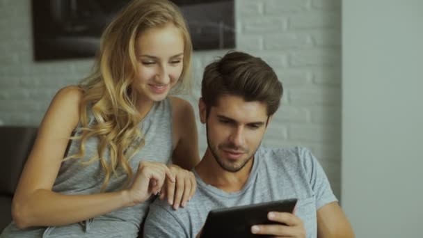 Pareja sonriente usando tableta en casa . — Vídeos de Stock