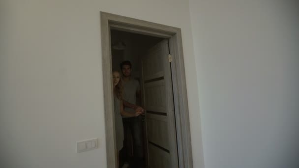 Young couple entering in their new flat. — Stock video