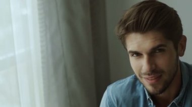 Mutlu genç adam. Casual tişörtlü geçti ve evde gülümseyen silah tutmak yakışıklı genç adam portresi