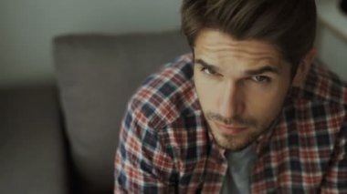 Mutlu genç adam. Sıradan gömlekli, kollarını kavuşturup gülümseyen yakışıklı bir gencin portresi.