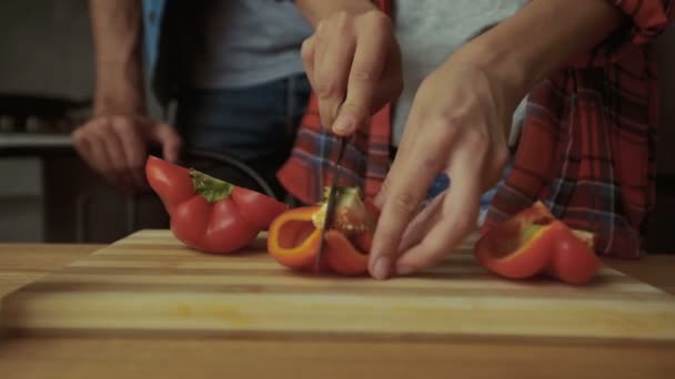 Vrouw en een man snijden peper. — Stockvideo