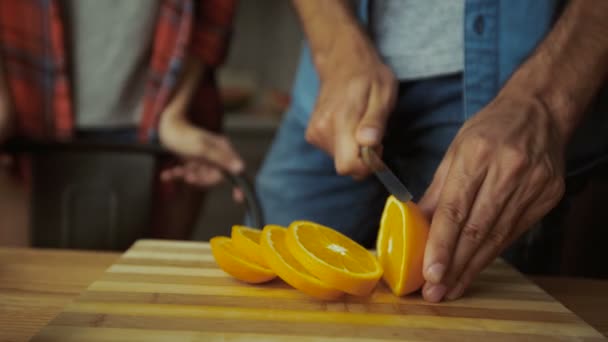 Gros plan des mains coupant des oranges pour le petit déjeuner . — Video