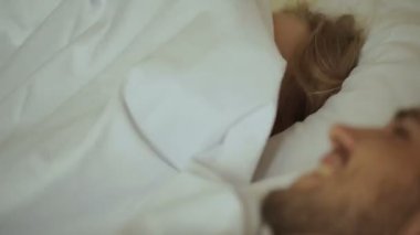 Genç çift yatakta kalmak.
