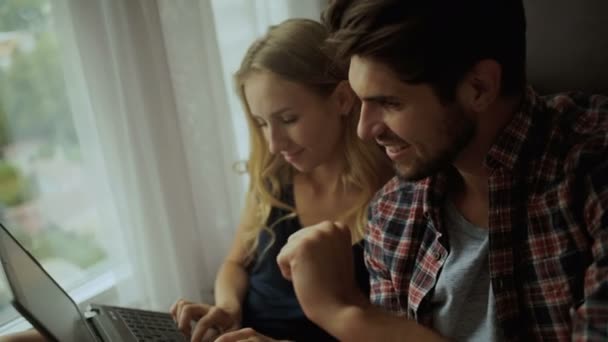 Beautiful couple working on a laptop at home. — Stock video