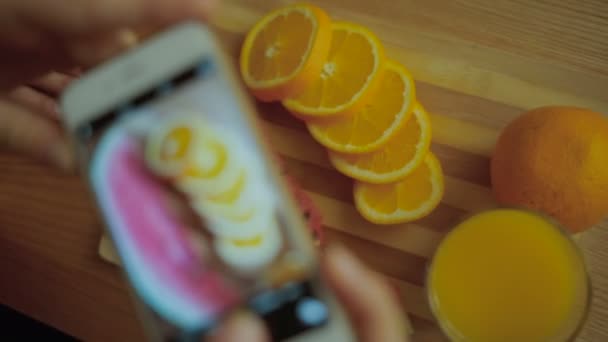 Lady taking pictures of watermelon and oranges. — ストック動画