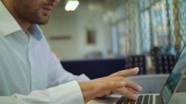 Geçici iş günü. Onun çalışma evinde otururken diz üstü kullanan dalgın genç yakışıklı adam